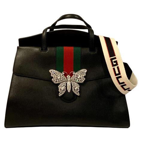 red gucci bag with butterfly.